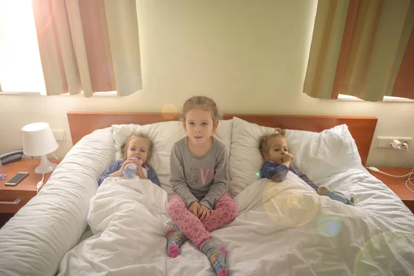 Три маленькие сестры, лежащие в кроватях — стоковое фото