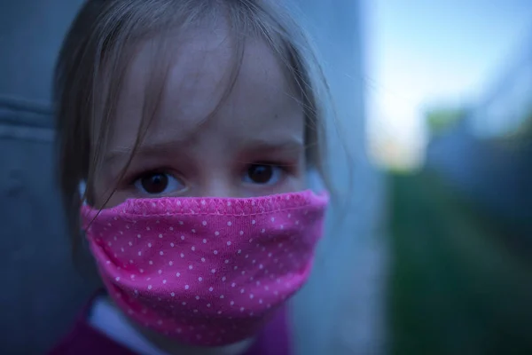 A child in Eastern Europe protecting himself from a coronavirus with a face mask. Fear in the eyes.