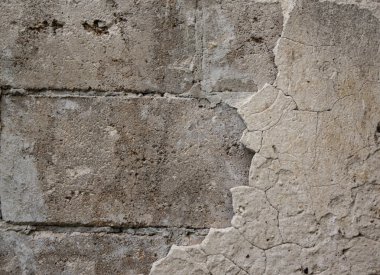 Tuğla duvarın bir kısmı ve alçının kabuk soyucu yüzeyi.