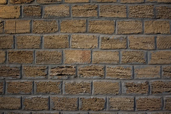 masonry wall of large dark yellow brick