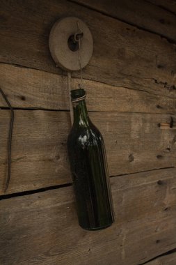 Ahşap bir arka planda koyu yeşil şişe. Boş cam şişe. tel asma şişesi