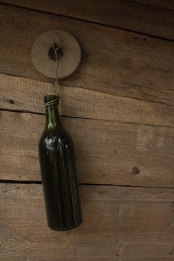 Ahşap bir arka planda koyu yeşil boş şişe. Boş cam şişe. tel asma şişesi