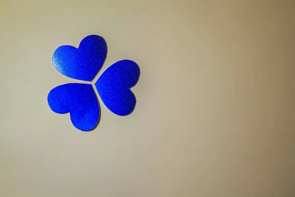 blue shamrock closeup of paper hearts on a beige background