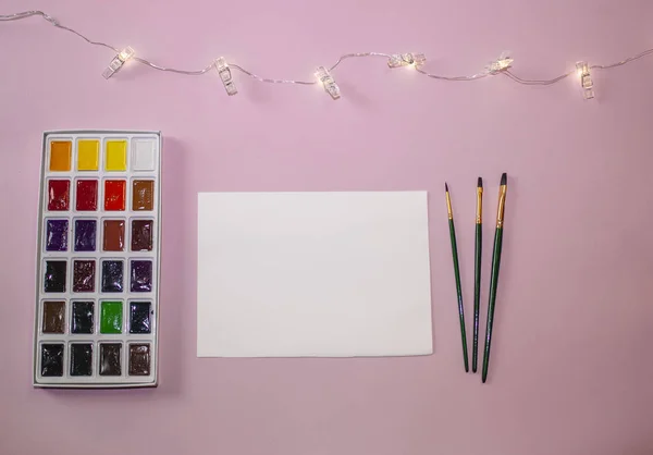 Una Hoja Papel Blanco Blanco Sobre Fondo Rosa Junto Pinturas — Foto de Stock