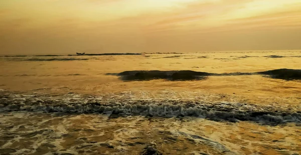 Coucher de soleil incroyable sur la plage avec un horizon sans fin et des figures solitaires au loin, et d'incroyables vagues mousseuses . — Photo