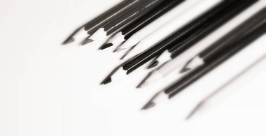 Beyaz arka planda bir paket kalem yakın plan. Siyah ve beyaz.