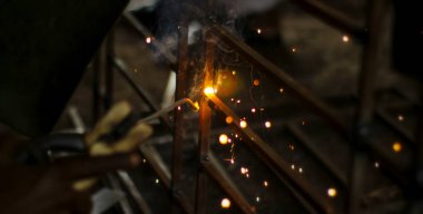 Metal kaynaklama. Elektrikli ısıtmadan kıvılcımlar. Atölyede çalış. Malzemelerin güvenilir şekilde birleştirilmesi. Demirin üretimi. Metal ustasının işi..