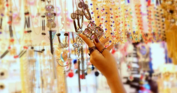 Hand of young lady selecting jewelry at a jewelry shop.Selective focus .