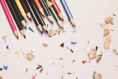 Renkli kalemler yığını ve beyaz bir arkaplan üzerinde tıraş. İş ve eğitim kavramı. Metin için kopya alanı olan seçmeli odak.