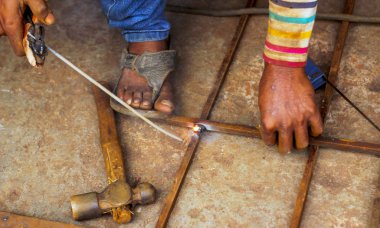 Metal kaynaklama. Elektrikli ısıtmadan kıvılcımlar. Atölyede çalış. Malzemelerin güvenilir şekilde birleştirilmesi. Demirin üretimi. Metal ustasının işi..