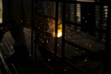 Metal kaynaklama. Elektrikli ısıtmadan kıvılcımlar. Atölyede çalış. Malzemelerin güvenilir şekilde birleştirilmesi. Demirin üretimi. Metal ustasının işi..