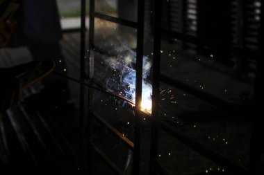 Metal kaynaklama. Elektrikli ısıtmadan kıvılcımlar. Atölyede çalış. Malzemelerin güvenilir şekilde birleştirilmesi. Demirin üretimi. Metal ustasının işi..