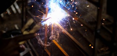 Metal kaynaklama. Elektrikli ısıtmadan kıvılcımlar. Demir, materyaller. Sanatsal kaynak, kıvılcımlar, endüstriyel arka plan. .