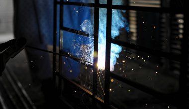 Metal kaynaklama. Elektrikli ısıtmadan kıvılcımlar. Demir, materyaller. Sanatsal kaynak, kıvılcımlar, endüstriyel arka plan. .