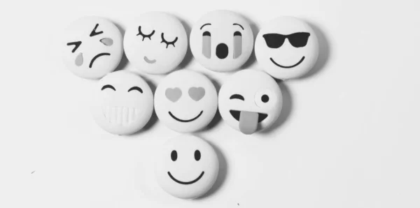 Seçili nesneye odaklı siyah beyaz arkaplan üzerinde çeşitli duygu emojisi .