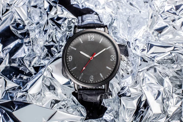 Modern watch without logo on foil background. Studio shot close-up.