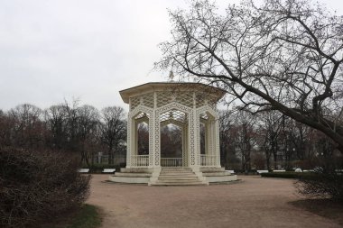 Sonbaharda boş bir parktaki klasik beyaz taş çardak..