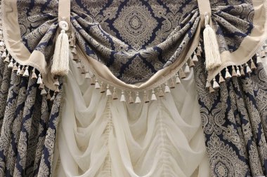 Klasik bir iç mekanın tasarımında dekoratif bir perde unsuru. Beyaz Roma panjurlarındaki fırça ve tutuculardan gelen bej izleri olan mavi..