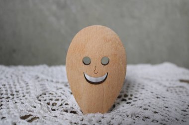 Ağzı delik, gözleri beyaz dantel bir masa örtüsü ve gri bir duvar karşısında gülümseyen tahta bir kaşık. Kaşıkçı iyi bir iştah ve ince bir vücut istiyor. Onun yardımıyla, kolayca en iyisini bulabilirsin.