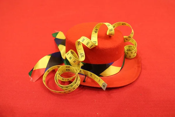 Желтая Лента Обернутая Змеями Лежит Красной Шляпе Разноцветной Лентой Красном — стоковое фото