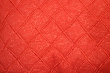 Kırmızı kumaşta kırmızı dikişli tekstil dokusu.  