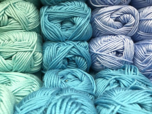 Texture of different sharpness from balls of yarn of cold blue shades. Mobile photo with store lighting.