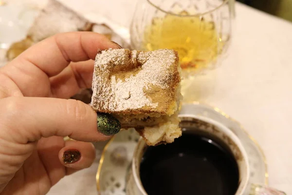 Кусок Домашнего Торта Сахарной Пудрой Руке Женщины Фоне Чашки Кофе — стоковое фото