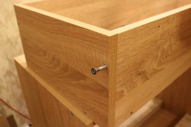 Diğer elementlerin arka planında yarım yamalak vida olan ahşap bir yapı elementi..