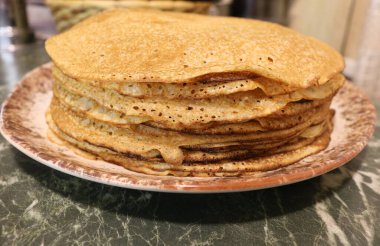 Yeşil taş bir masanın üzerinde duran tabağın üzerinde duran bir yığın güzel gözlemenin yan görüntüsü.
