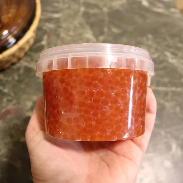 Vaso Plastica Trasparente Chiuso Con Caviale Rosso Mano Umana Sullo — Foto Stock