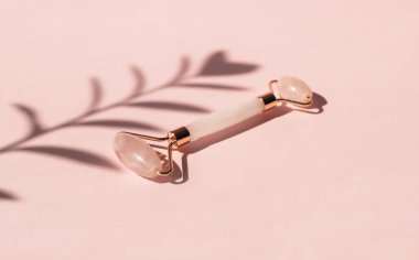 Pembe doğal nefrit için masaj kuvars silindiri. Gua Sha masaj aletleri. Evde yaş sınırlaması ve kaldırma. Cilt bakımı yüz masajı ve rahatlama konsepti. 