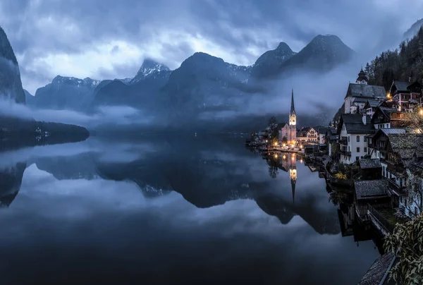 Köyün Hallstatt Gölü nün şafak arka planı. Bahar. yansıma, kilise, göl, dağlar