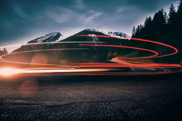 Dağ doruklarına zemin karşı bir araba izleme ışıkları