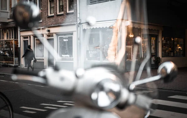 Vintage bir scooter ön planda. Arka plan Amsterdam şehir mimarisi