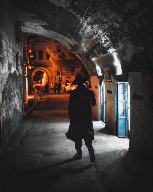 Bir sokakta adam eski şehrin Kudüs'te. Akşam, akşam, ışıklar yanıyor