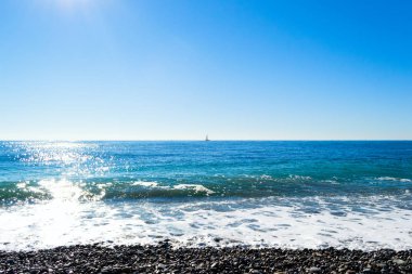 Taşlı bir kumsalda kırma dalgalar spreyler şekillendirme