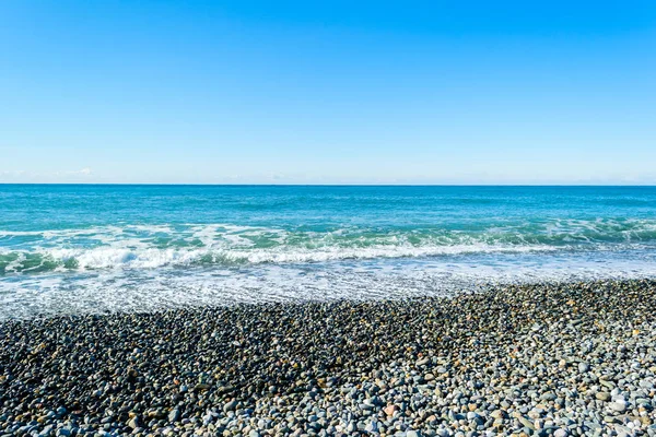 Waves breaking on a stony beach, forming sprays — Stock Photo, Image