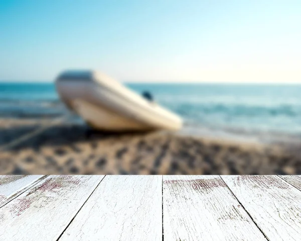 空の木製テーブル板。海岸でぼやけボート — ストック写真