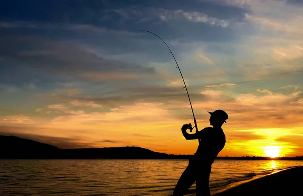 stock image Young man fishing at sunset