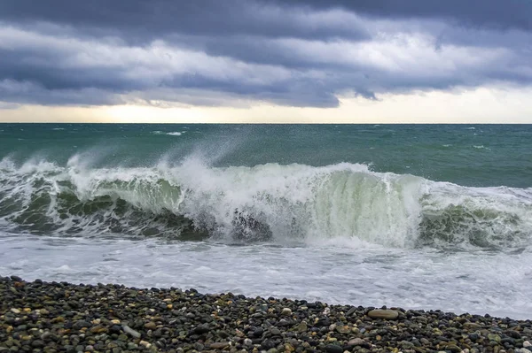 Vågstänk under stormig vind i havet vid stenstrand. — Stockfoto