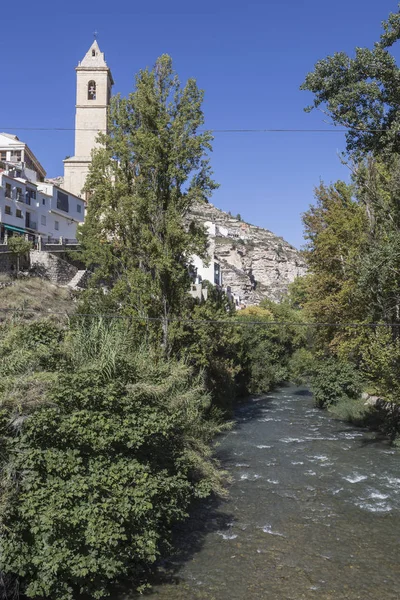 Clear waters of the river Jucar on the Roman bridge, to the left the Church of San Andres of styles late and neoclassic Gothic, take in Alcala del Jucar, Albacete province, Spain — 图库照片