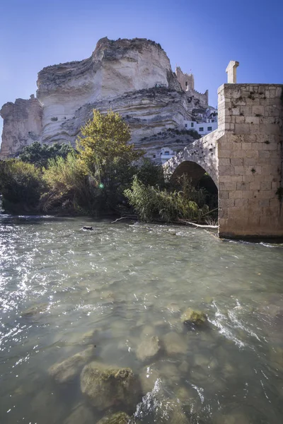 Puente romano, situado en la parte central de la ciudad, a su paso por el río Jucar, en la cima de la piedra caliza de montaña se encuentra el castillo de origen almohade del siglo XII, Alcalá del Jucar, España —  Fotos de Stock