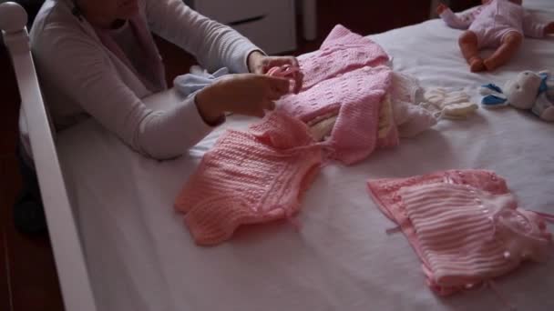 Γυναίκες προετοιμασία προσεκτικά τα ρούχα του μωρού — Αρχείο Βίντεο