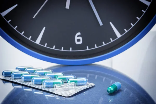 Some pills and red clock, daily medication treatment — Stock Photo, Image