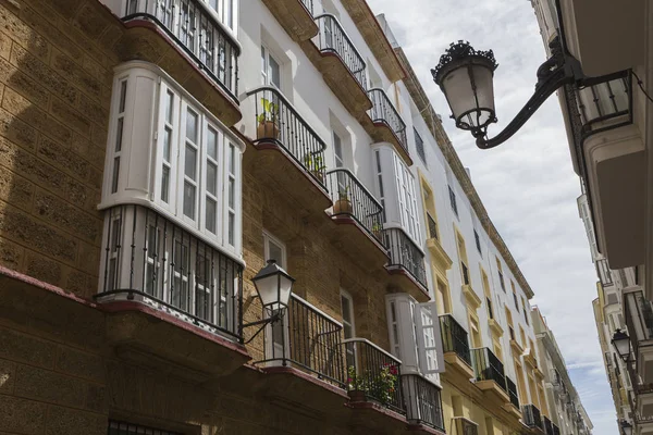 Dettaglio di balconi e grandi finestre sul periodo del XIX secolo, strada stretta con architettura tradizionale a Cadice, Andalusia, Spagna meridionale — Foto Stock