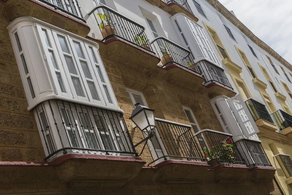 Dettaglio di balconi e grandi finestre sul periodo del XIX secolo, strada stretta con architettura tradizionale a Cadice, Andalusia, Spagna meridionale — Foto Stock