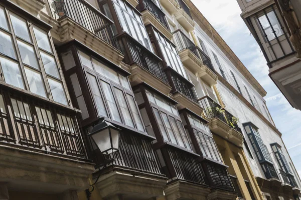 Detalhe de varandas e grandes janelas na época do século XIX, rua estreita com arquitetura tradicional em Cádiz, Andaluzia, sul da Espanha — Fotografia de Stock