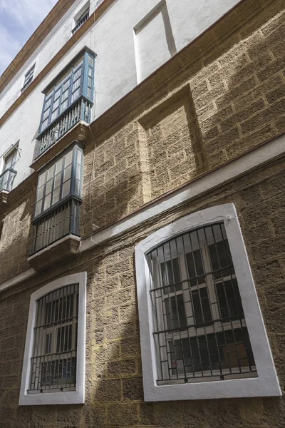 Detalhe de varandas e grandes janelas na época do século XIX, rua estreita com arquitetura tradicional em Cádiz, Andaluzia, sul da Espanha — Fotografia de Stock