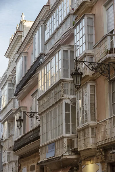 Detalhe de varandas e grandes janelas na época do século XIX, rua estreita com arquitetura tradicional em Cádiz, Andaluzia, sul da Espanha — Fotografia de Stock