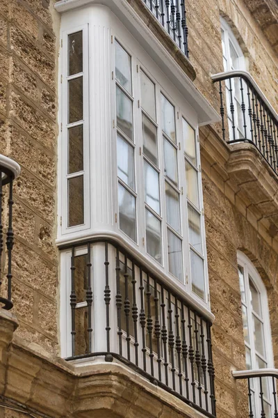 Detalhe de varandas e grandes janelas na época do século XIX, rua estreita com arquitetura tradicional em Cádiz, Andaluzia, sul da Espanha — Fotografia de Stock